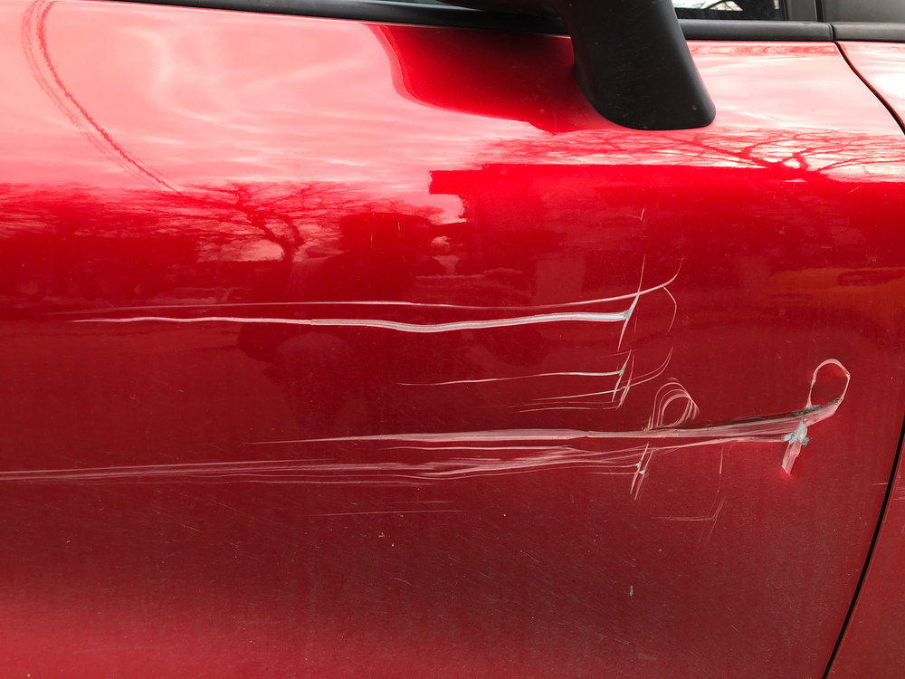 red car with a big scratch on its side door